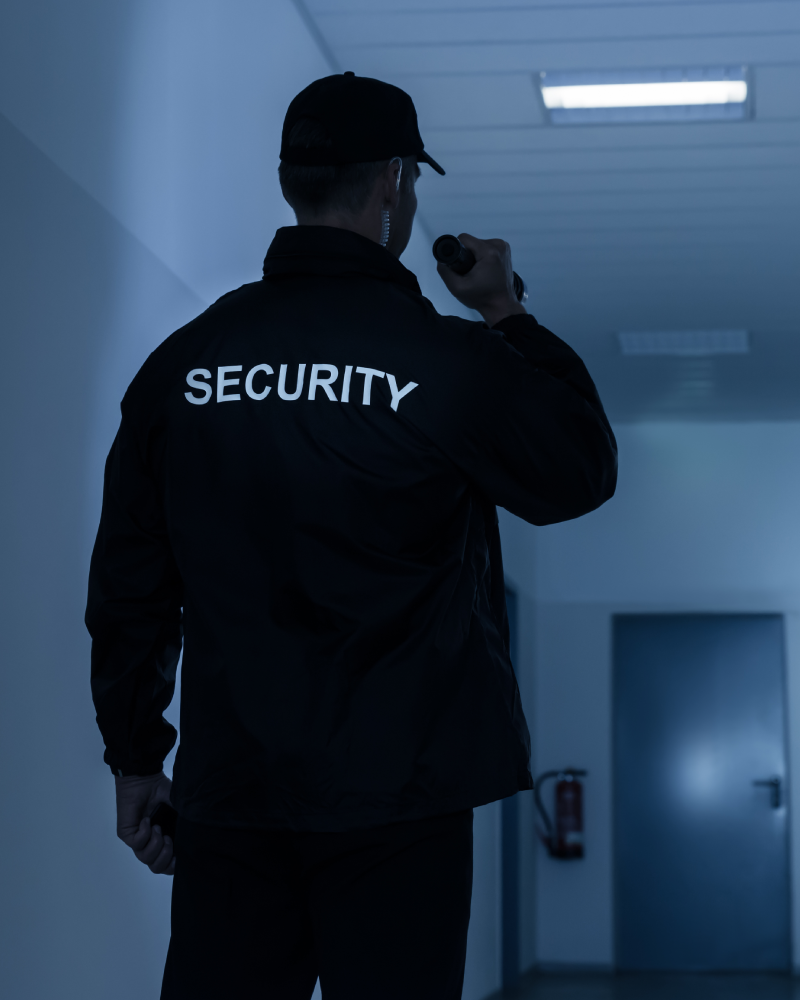 Security guard in dark corridor with radio.